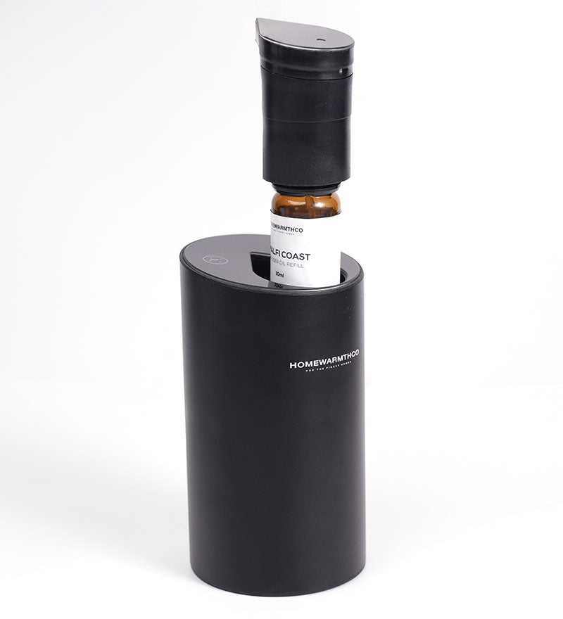 A 10ml bottle of 'Blooms by Night' diffuser oil bottle in an electric diffuser