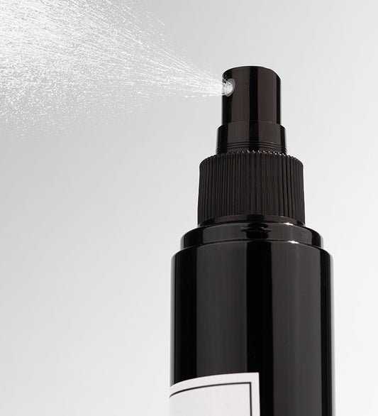 A black bottle of Vanilla Coconut room spray with a white label
