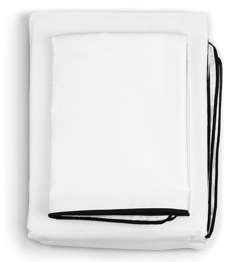 A white duvet cover set with black binding foldes on a floor