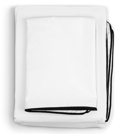 A white duvet cover set with black binding foldes on a floor