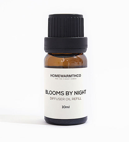 A 10ml bottle of 'Blooms by Night' diffuser oil with a black cap and white label, under natural lighting.