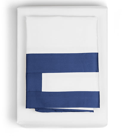 A set of navy and white patterned duvet covers displayed on a bed