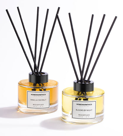 A reed diffuser set, with a clear bottle containing oil and black reeds