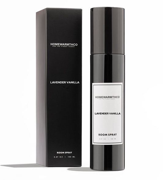 A black bottle of LAVENDER VANILLA room spray with a white label, placed next to its black box packaging with the same label.