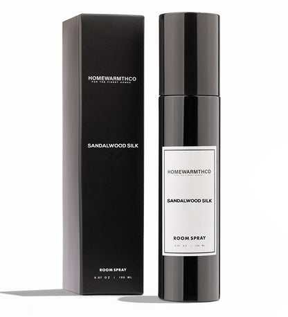 A black bottle of SANDALWOOD SILK room spray with a white label, standing next to its black packaging box.