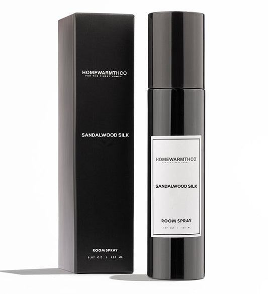 A black bottle of SANDALWOOD SILK room spray with a white label, standing next to its black packaging box.