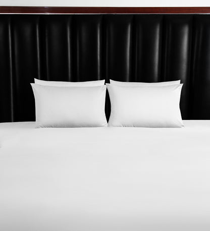 A set of white duvet covers displayed on a bed