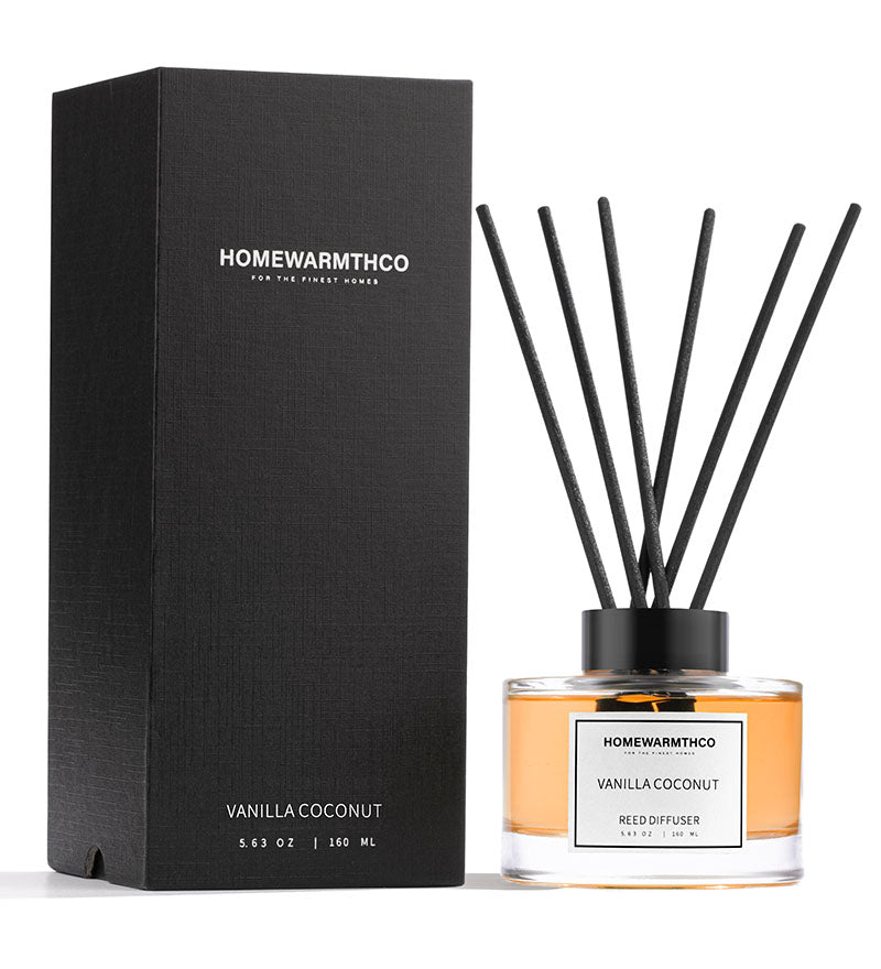A Vanilla Coconut scented reed diffuser by HomeWarmthCo, with clear glass bottle, black reeds, and black packaging box.