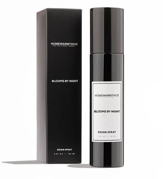 A black room spray bottle with white label text, placed next to its black box packaging, both labeled 'BLOOMS BY NIGHT ROOM SPRAY'.