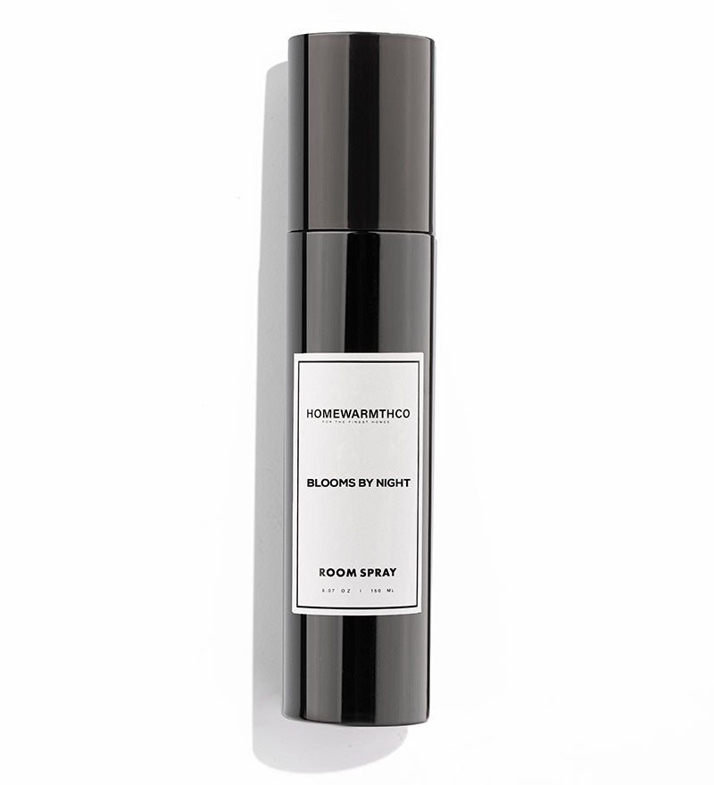 A black room spray bottle with white label text, placed next to its black box packaging
