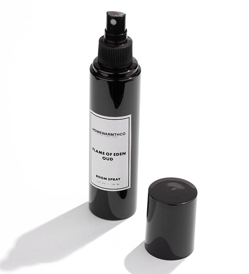 A black bottle of Flame of Eden Oud room spray with a white label
