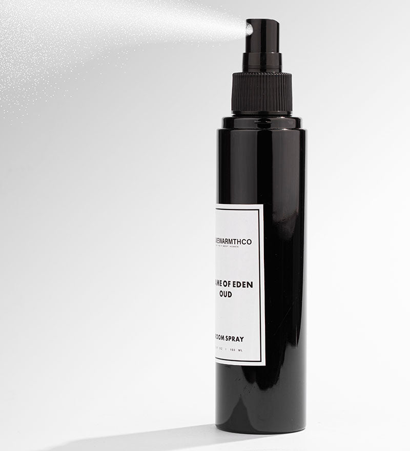 A black bottle of Flame of Eden Oud room spray with a white label