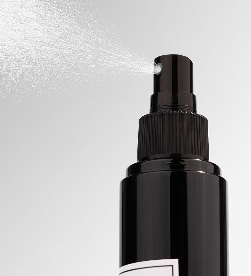 A black bottle of Floral Gardenia room spray with a white label