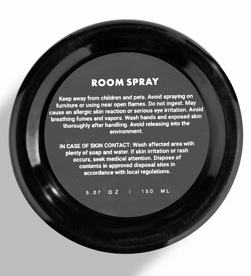A black bottle of Floral Gardenia room spray with customer guide