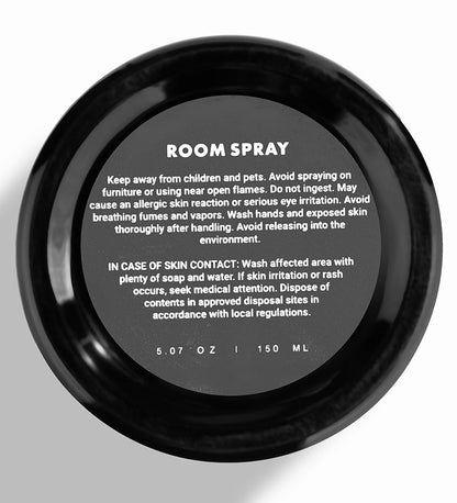 A black bottle of Floral Gardenia room spray with customer guide