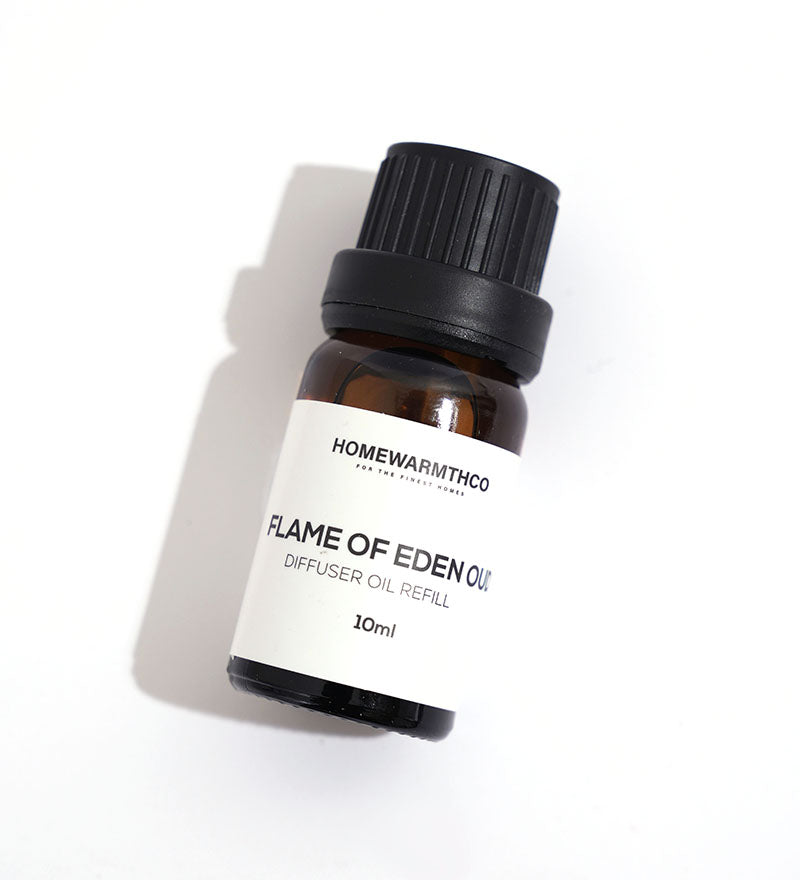A small dark-colored bottle labeled 'Flame of Eden Oud Diffuser Oil'