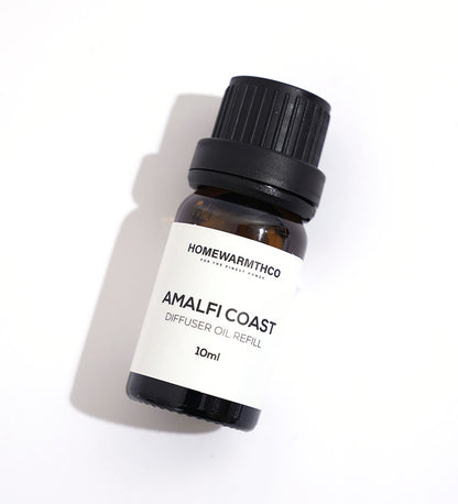 A small dark brown bottle with a black cap labeled 'Amalfi Coast Diffuser Oil 