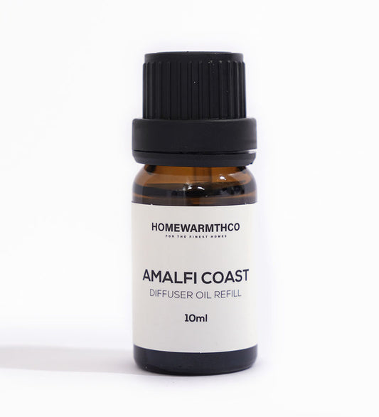 A small dark brown bottle with a black cap labeled 'Amalfi Coast Diffuser Oil Refill 10ml' by Homewarmthco.