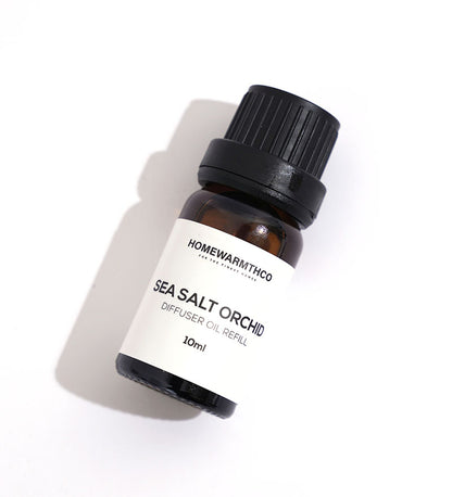 A small brown bottle with a black cap labeled 'Sea Salt Orchid Diffuser Oil
