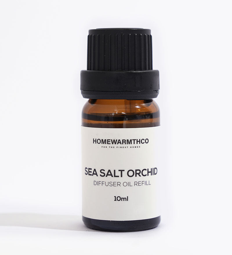 A small brown bottle with a black cap labeled 'Sea Salt Orchid Diffuser Oil Refill 10ml' from HomeWarmthCo.