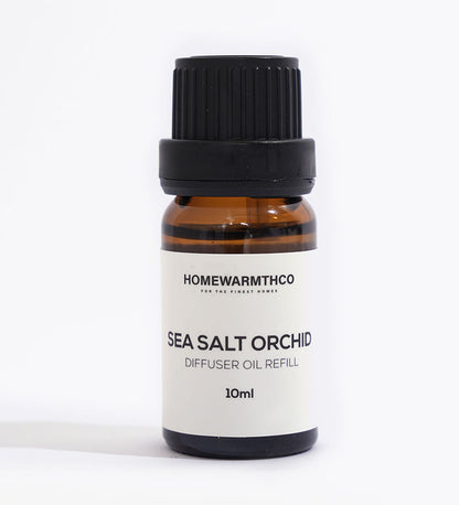 A small brown bottle with a black cap labeled 'Sea Salt Orchid Diffuser Oil Refill 10ml' from HomeWarmthCo.